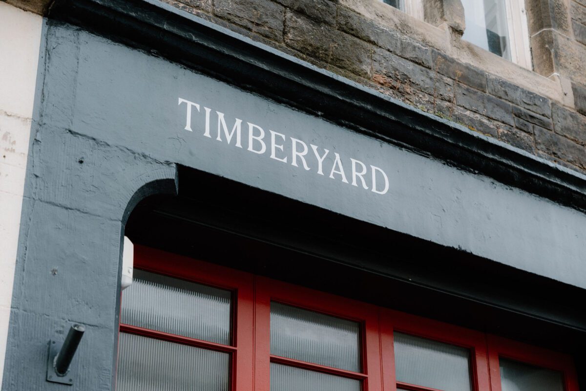 Timberyard sign above red-framed windows on a grey shopfront