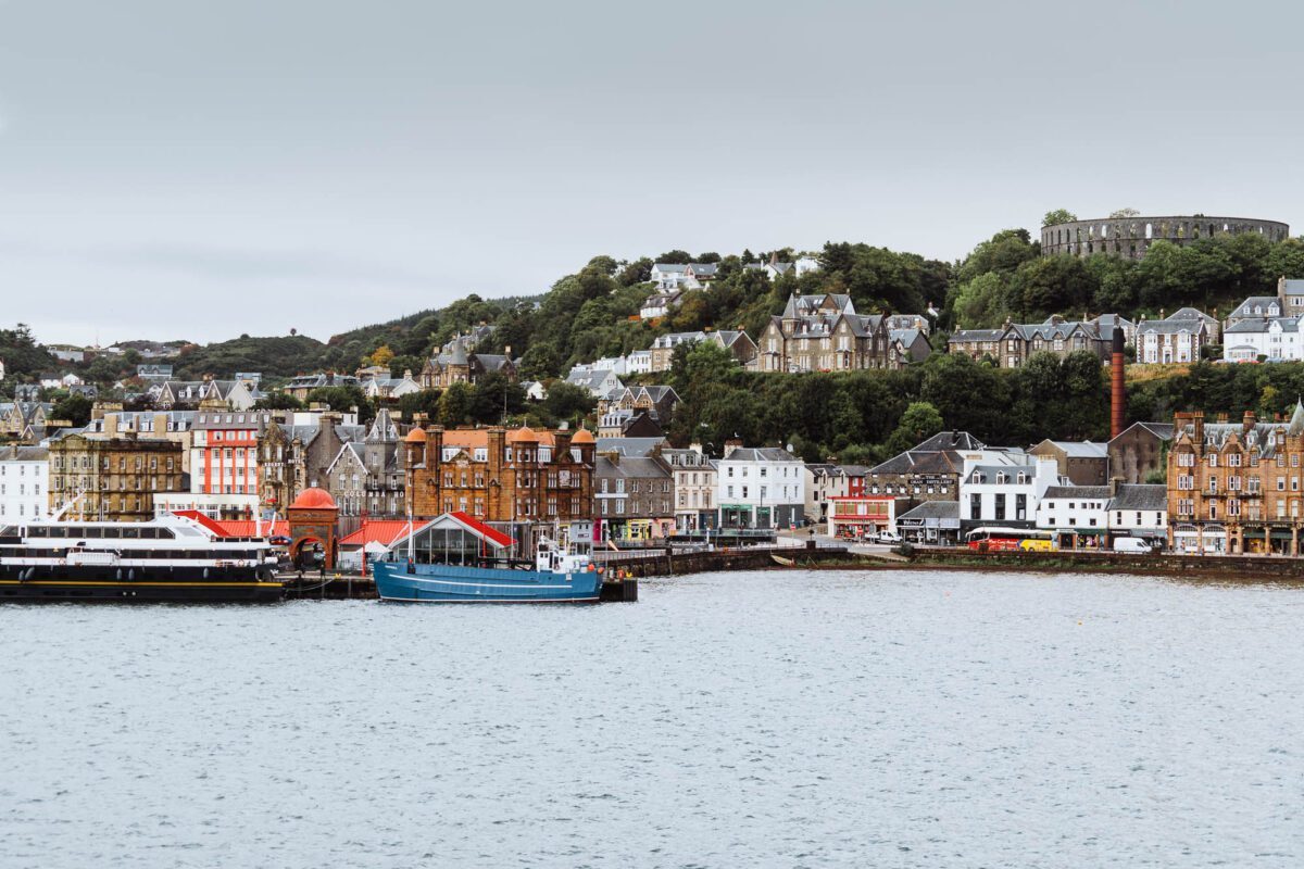 Colourful waterfront buildings and McCaig's Tower overlooking Oban harbour