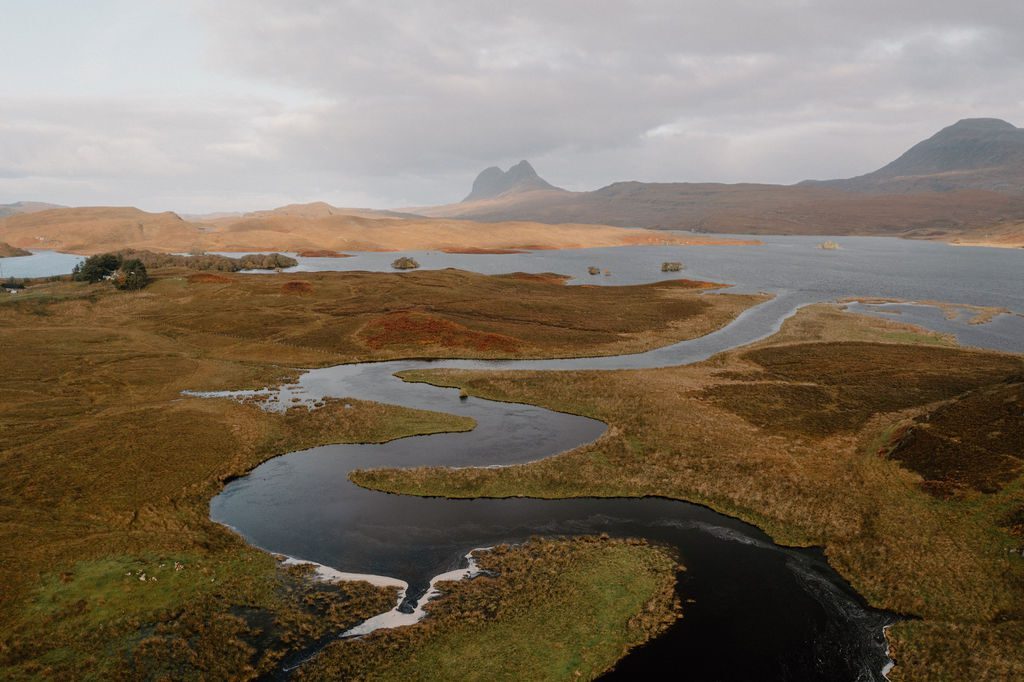 Winding river through moorland with Suilven and Cul Mor peaks beyond