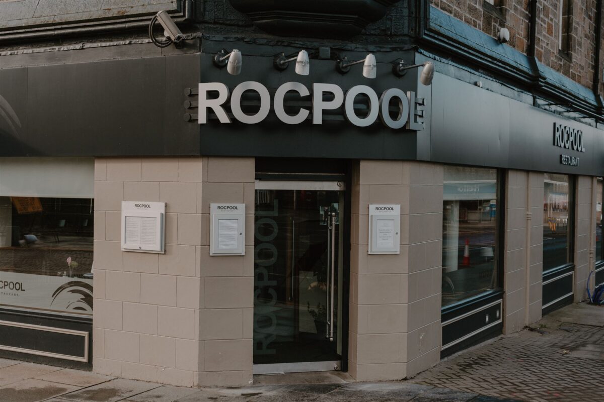 Corner entrance of Rocpool restaurant with black canopy and menus displayed outside