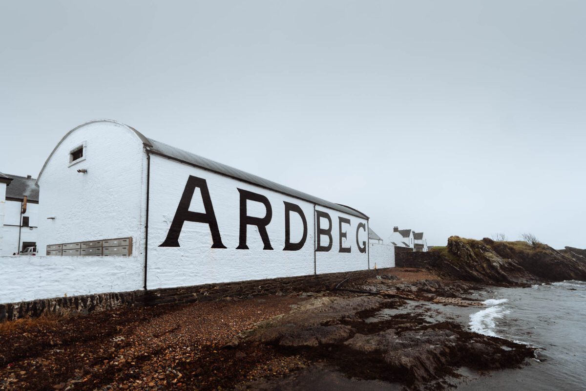 Ardbeg distillery's whitewashed warehouse wall beside the rocky Islay shore