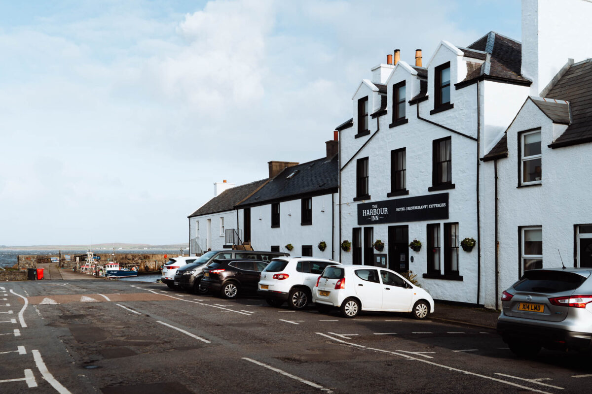 The Harbour Inn and its neighbours by the harbour in Bowmore, the loch beyond.