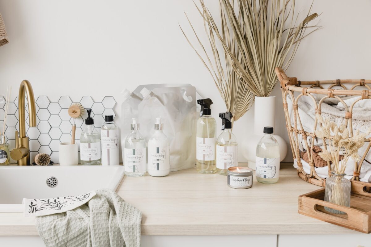 Bathroom counter with labelled bottles, dried grasses and a woven storage basket