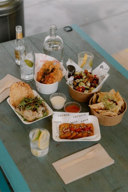 Street food spread on a blue table, with Chix and Fabrica packaging visible